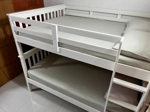 a white bunk bed with a ladder on it at Meu Loft Geribá em Búzios in Búzios