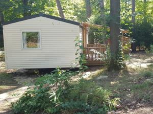 a small white house in the woods with a tree at MBIMBE AGNES in Saint-Chéron