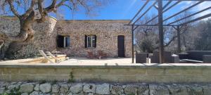 un edificio de piedra con una mesa y sillas delante de él en Stone House Li Turchi 2 en Leuca