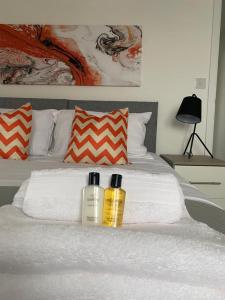 dos botellas de odorizantes sentadas encima de una cama en Henry Blythe Gardens en Thame