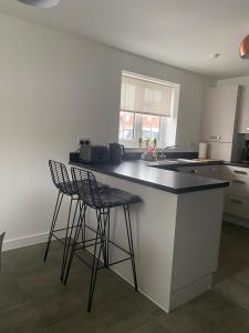 a kitchen with two bar stools and a counter top at Henry Blythe Gardens in Thame