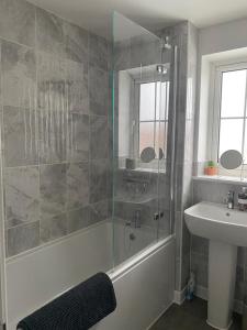 a bathroom with a shower and a tub and a sink at Henry Blythe Gardens in Thame