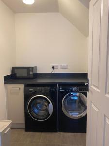 a laundry room with a washer and dryer at Henry Blythe Gardens in Thame