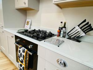 a kitchen with a stove top oven in a kitchen at Vindelis Cottage Chesil Beach in Portland +28 photos