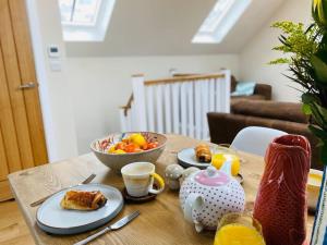 a table with a bowl of food and a bowl of fruit at Vindelis Cottage Chesil Beach in Portland
