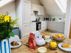 a kitchen with a table with food on it at Vindelis Cottage Chesil Beach in Portland