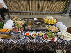 a table with plates of food on top at Minh Khang Homestay - Làng đá cổ Khuổi Ky in Cao Bằng