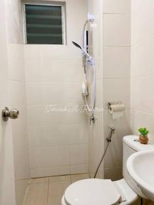 een badkamer met een douche, een toilet en een wastafel bij Teratak Al-Kautsar Homestay in Kuching