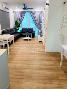 een woonkamer met een zwarte bank en een houten vloer bij Teratak Al-Kautsar Homestay in Kuching