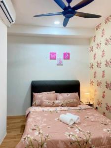 een slaapkamer met een roze bed en een plafondventilator bij Teratak Al-Kautsar Homestay in Kuching