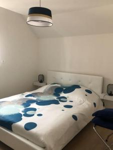 um quarto com uma cama com flores azuis em Une maison agréable pour se détendre em Saint-Quentin