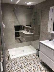 uma casa de banho com um chuveiro, um lavatório e um espelho. em Une maison agréable pour se détendre em Saint-Quentin