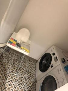 uma lavandaria com uma máquina de lavar roupa num quarto em Une maison agréable pour se détendre em Saint-Quentin