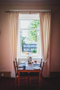 una mesa y sillas frente a una ventana en Heatherfield House, en Oban