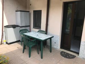 una mesa verde y sillas en un patio en Naborre&Felice Apartment, en Lodi Vecchio