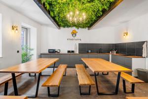 a room with wooden tables and a kitchen at Stadtaffe - Chic Hostel VIE in Vienna