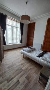 um quarto com uma cama e piso em madeira em STUDIOS ET APPARTEMENTS EN CENTRE VILLE Boulogne sur mer em Boulogne-sur-Mer