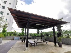 einen Picknicktisch und eine Bank unter einem Pavillon in der Unterkunft B2014 Platino 4Bedroom Netflix Paradigm Mall STAY in Johor Bahru