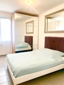 una camera con un grande letto e uno specchio di Marseille 60 m2 terrasse et parking a Marsiglia