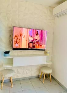 a flat screen tv on a wall with two chairs at Marseille 60 m2 terrasse et parking in Marseille