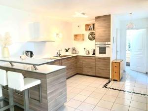 uma cozinha com armários de madeira e piso em azulejo branco em Marseille 60 m2 terrasse et parking em Marselha