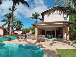 a villa with a swimming pool and a house at Kauano Pousada Barequeçaba in São Sebastião