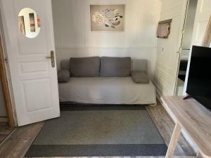 eine weiße Couch in einem Zimmer neben einer Tür in der Unterkunft CHALET AVEC SPA en fonction du 15 mai au 30 septembre in Lucciana