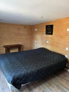 um quarto com uma cama com uma placa na parede em CHALET AVEC SPA en fonction du 15 mai au 30 septembre em Lucciana