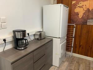 a kitchen with a refrigerator and a coffee maker on a counter at CHALET AVEC SPA en fonction du 15 mai au 30 septembre in Lucciana