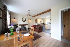 a kitchen and living room with a table and a dining room at 1 Kirkbeck Cottage Coniston in Coniston