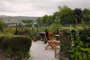 eine Terrasse mit einem Tisch und Stühlen im Garten in der Unterkunft 1 Kirkbeck Cottage Coniston in Coniston