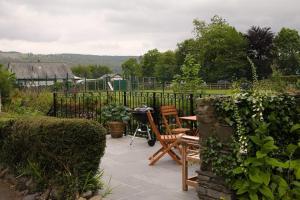 a patio with a table and chairs in a garden at 1 Kirkbeck Cottage Coniston in Coniston