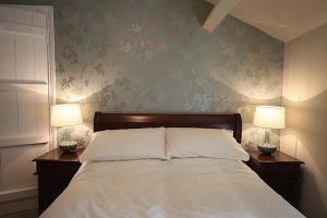 ein Schlafzimmer mit einem Bett mit zwei Lampen an Tischen in der Unterkunft 1 Kirkbeck Cottage Coniston in Coniston