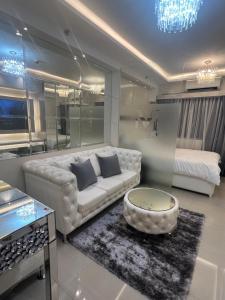 ein Wohnzimmer mit einem Sofa und einem Bett in der Unterkunft MiamiViceLuxuryStays at Shore2 in Manila
