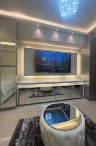sala de estar con TV grande y bañera en MiamiViceLuxuryStays at Shore2, en Manila