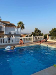 a group of people playing in a swimming pool at Villa Paraiso - Appartement 2 pièces privatif in Alhaurín de la Torre