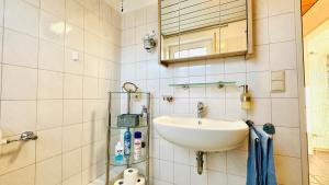 uma casa de banho com um lavatório e um espelho em Küstenliebe em Norden