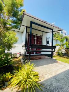 una pequeña casa con un banco delante en KORA-GREAT Airport Phuket en Nai Yang Beach