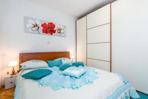a bedroom with a large bed with blue pillows at Apartment Angel in Split