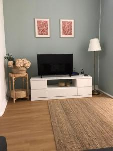 ein Wohnzimmer mit einem TV auf einem weißen Entertainment-Center in der Unterkunft Santo Cristo Apartments in Ponta Delgada