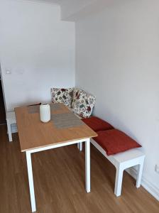 einen Tisch und eine Bank mit einem roten Kissen in der Unterkunft Santo Cristo Apartments in Ponta Delgada
