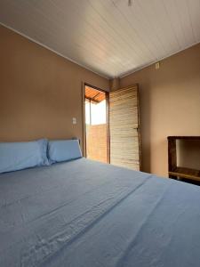 a large bed in a room with a window at Pousada Canela de Ema in Mateiros
