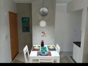 a white dining room table with white chairs and a white table and chairsktop at Apartamento Sol Poente in Ribeirão Preto