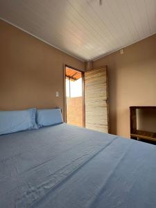 a large bed in a room with a window at Pousada Canela de Ema in Mateiros