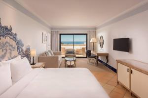 a hotel room with a bed and a living room at Pine Cliffs Hotel, a Luxury Collection Resort, Algarve in Albufeira