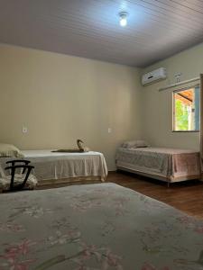um quarto com duas camas e uma janela em Pousada Canela de Ema em Mateiros