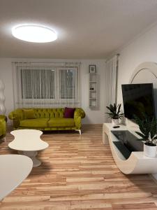 a living room with a green couch and tables at O&V Apartment in Waldshut-Tiengen
