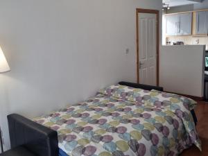 Modern Apartment good distance from Dublin City and Airport 4people في دبلن: غرفة نوم مع سرير ولحاف ملون