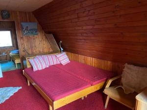 a room with a bed in a wooden cabin at Chata Hugo in Jarabá