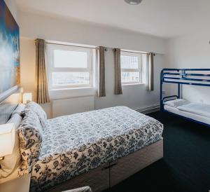 a bedroom with a bed and two bunk beds at Kinlay Hostel Eyre Square in Galway